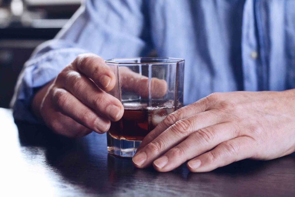 Man holding alcoholic drink at bar